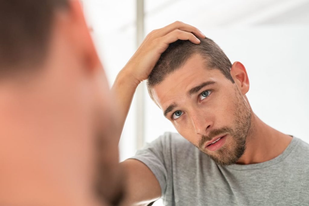uomo controllo psoriasi in cuoio capelluto