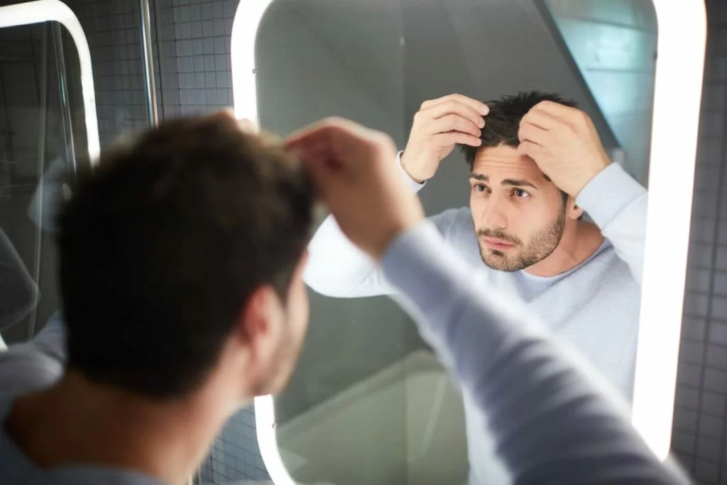 uomo guarda capelli